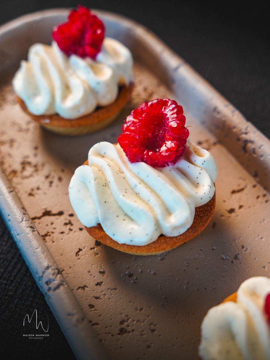 Tartelette à la crème vanille surmontée d'une framboise fraîche